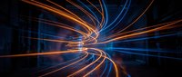 Glowing orange and blue light trails converge in dynamic motion, creating an abstract tunnel effect with streaking energy lines for technology and digital design backgrounds.