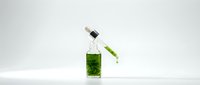 Glass bottle with green liquid and dropper pipette for laboratory research and scientific experiments on white background.