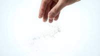 Hand sprinkling salt crystals against a white background, capturing the motion of seasoning food in a clean, minimalist culinary concept.