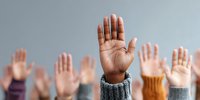 Diverse group of people raising hands showing unity, participation and volunteering spirit in community engagement and social activism.