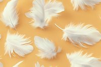 Delicate white feathers floating on warm golden background create ethereal pattern. Seamless design for fabric, wallpaper and creative projects.
