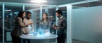 Diverse business team analyzing holographic data visualization in modern office meeting room with futuristic technology interface for strategic planning.