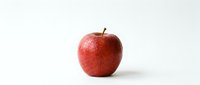 Fresh red apple with natural skin texture isolated on white background for healthy eating and nutrition concepts.