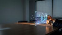 Young professional male displaying holographic financial charts and growth analytics on transparent digital display in modern conference room setting for business presentation.