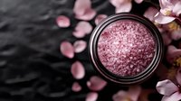 Pink bath salt in glass jar with scattered cherry blossom petals on dark stone background, spa and wellness composition for relaxation and aromatherapy.