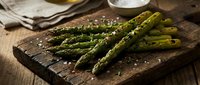 Grilled asparagus spears with sea salt on rustic wooden board, ready for cooking or serving as a healthy vegetable side dish.