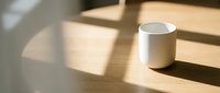 White ceramic mug on wooden table with natural sunlight and shadows, suitable for product mockups, branding, and beverage marketing.