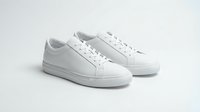 Clean white leather sneakers pair isolated on light background for fashion footwear design and casual style concepts.