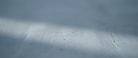 Pristine snow-covered mountain slope with dramatic overcast sky and scattered dark spots creating winter wilderness landscape for outdoor adventure concepts.