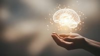 Hands holding glowing brain with sparkling lights representing artificial intelligence, mental health, innovation and cognitive science concepts.