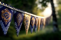 Decorative bunting flags with ornate golden patterns hanging outdoors in soft natural light for festive celebrations and party decorations.