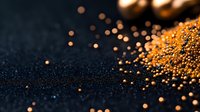 Vibrant orange spice powder scattered on dark background with selective focus and bokeh effect creates dramatic culinary composition for food photography.