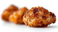 Crispy breaded chicken nuggets with golden brown crust and tender meat inside on white background, selective focus on front piece, macro food photography.