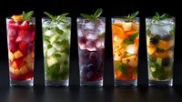 Fresh fruit mojito cocktails with berries, mint leaves and ice in tall glasses on dark background. Colorful summer drinks for menu and bar design.