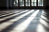 Dramatic shadows and light beams streaming through windows onto empty floor create geometric patterns in minimalist interior space, moody atmospheric scene.
