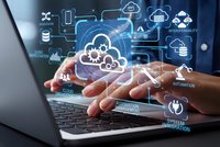 Businessman hands typing on laptop with cloud computing network and digital technology icons floating above keyboard for modern business solutions.