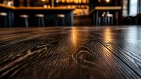 Rustic wooden table surface with warm lighting in blurred restaurant background for product display and food photography mockups.