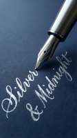 Silver fountain pen with nib writing cursive text on dark blue paper, suitable for business correspondence, calligraphy, writing, and formal document design projects.