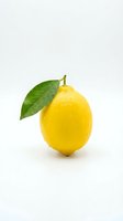 Fresh yellow lemon with green leaf isolated on white background for healthy eating, cooking, beverage and citrus fruit concepts.
