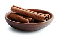 Aromatic cinnamon sticks in wooden bowl against white background, fresh spice for cooking, baking and flavoring beverages, isolated with soft shadow.