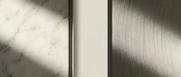 Minimalist architectural detail with natural sunlight casting geometric shadows on textured wall surfaces creating modern interior design elements.