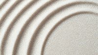Concentric brown circles pattern in sand creates zen garden meditation effect. Smooth raked lines on light beige background form peaceful minimalist design.