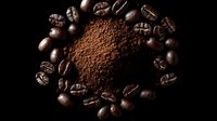 Dark roasted coffee beans arranged in circle around heap of ground coffee powder on black background, dramatic lighting creates rich contrast and texture.