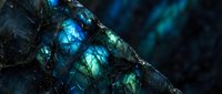 Iridescent labradorite mineral crystal displaying vibrant blue and green flash colors with natural stone texture for geology education and jewelry design.