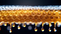 Fresh honey drips from natural honeycomb cells in golden amber color with pure droplets falling against dark background, showing raw organic sweetness.
