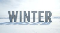 Large concrete letters spelling WINTER stand on a vast snowy landscape under a pale winter sky, evoking cold season themes.