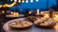 Cozy evening appetizer spread with hummus, olives, and crackers on wooden table with warm candlelight and bokeh lights creating intimate dining atmosphere.
