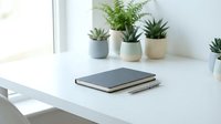 Clean minimalist workspace with closed laptop and small potted plants on white desk near window creating peaceful home office environment for productivity.