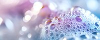 Macro shot of soap bubbles with iridescent rainbow colors and bokeh effect on blurred background, creating dreamy abstract texture for creative designs.