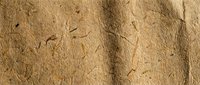 Natural brown recycled paper texture with organic fibers and rough surface for eco-friendly design projects and sustainable packaging concepts.