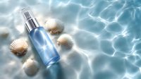 Cosmetic blue glass spray bottle with seashells on rippling water surface in sunlight, creating luxurious spa atmosphere for beauty and skincare product presentation.