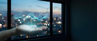 Businessman hand holding digital hologram with upward trending graph and cityscape at night, representing financial growth and data analytics for business success.