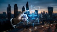 Businessman hand touching digital justice scales hologram with city skyline at dusk. Legal technology concept for law firms and corporate compliance solutions.
