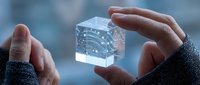Hands holding transparent cube with glowing digital network connections and data visualization for technology and innovation concepts.