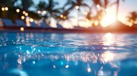 Tranquil split view of swimming pool water surface at sunset with bokeh lights and palm trees silhouettes, tropical vacation atmosphere for resort advertising.