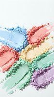 Colorful crushed eyeshadow powder makeup palette with rainbow hues scattered on white background for beauty and cosmetics industry applications.