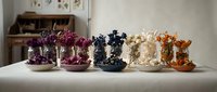 Colorful decorative ceramic bowls with floral patterns arranged on white table in modern kitchen interior for home decor and tableware display.