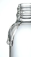 Clear water pouring from tilted glass jar isolated on white background, suitable for beverage, hydration, and wellness design projects.