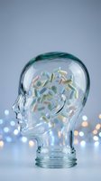 Glass head silhouette filled with colorful pills and capsules representing mental health medication and pharmaceutical treatment concepts.