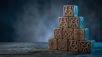 Wooden blocks stacked in pyramid formation with carved symbols and turquoise accents on dark moody background, representing knowledge, learning, and organizational concepts.