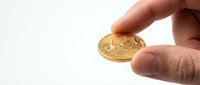 Hand holding golden bitcoin cryptocurrency coin on white background for digital finance and investment concepts.