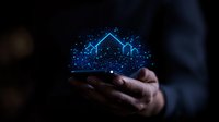 Professional hands holding glowing blue holographic house silhouette with sparkle effect against dark background, representing digital real estate and smart home technology.