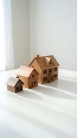 Three wooden house models of different sizes arranged on a white surface, symbolizing real estate growth, property investment, and family housing concepts.