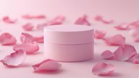 Pink cosmetic jar surrounded by delicate rose petals on soft pink background, creating romantic spa and beauty product composition for skincare packaging.