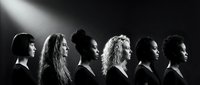Diverse group of women in profile silhouette under dramatic spotlight, showcasing unity and empowerment in black and white artistic composition.