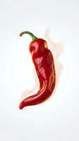 Fresh red chili pepper with green stem isolated on white background with flame effect, suitable for food packaging, culinary designs, and spicy ingredient marketing materials.